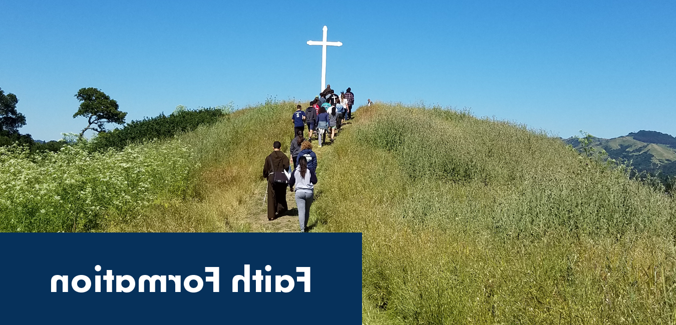 Image of students and a priest hiking up a hill with a white wooden cross at the top and the words &quot;Faith Formation&quot;