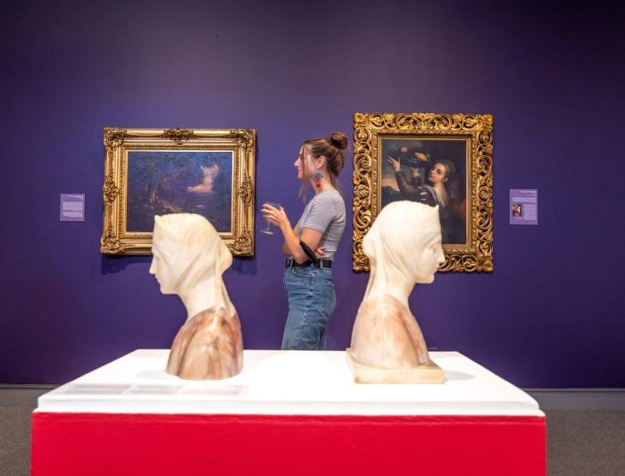 一个学生站在艺术博物馆的两个半身像之间
